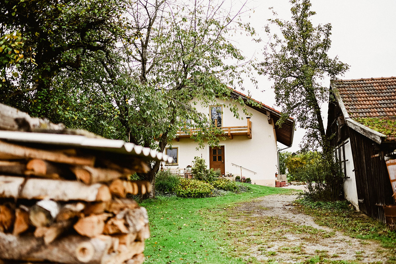 Naturheilpraxis Bianca Ahollinger, Ansicht Haus mit Holzstapel im Vordergrund